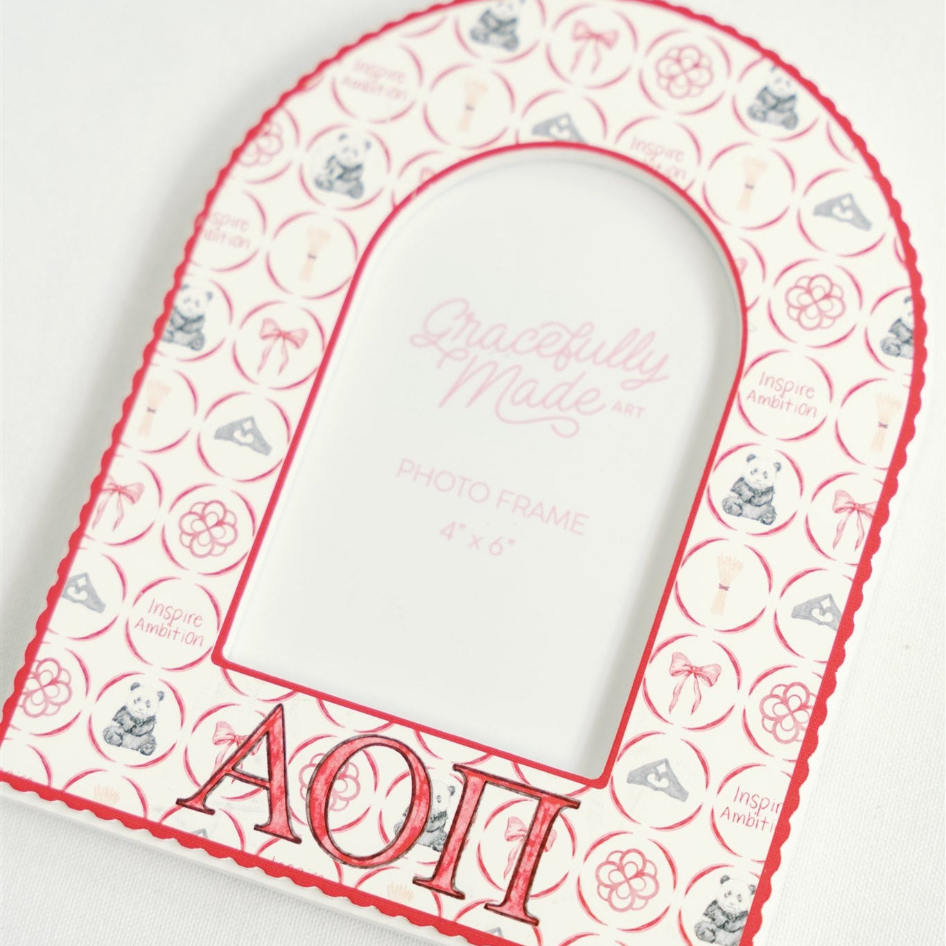 Decorative arched picture frame with Alpha Omicron Pi initials on a white background