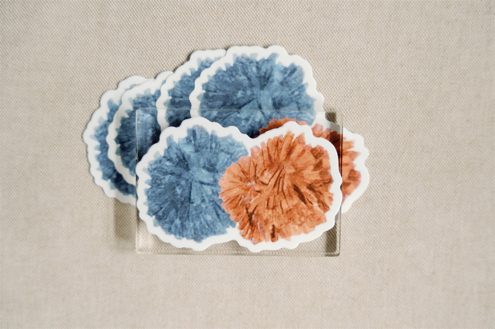 Sticker of an orange and blue pom pom.
