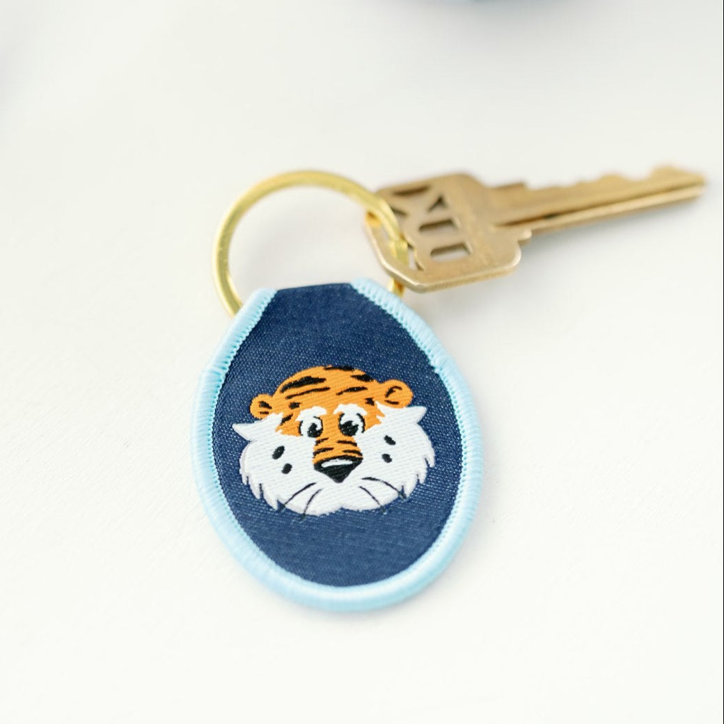 Navy blue keychain with light blue rim and Auburn embroidered on it.