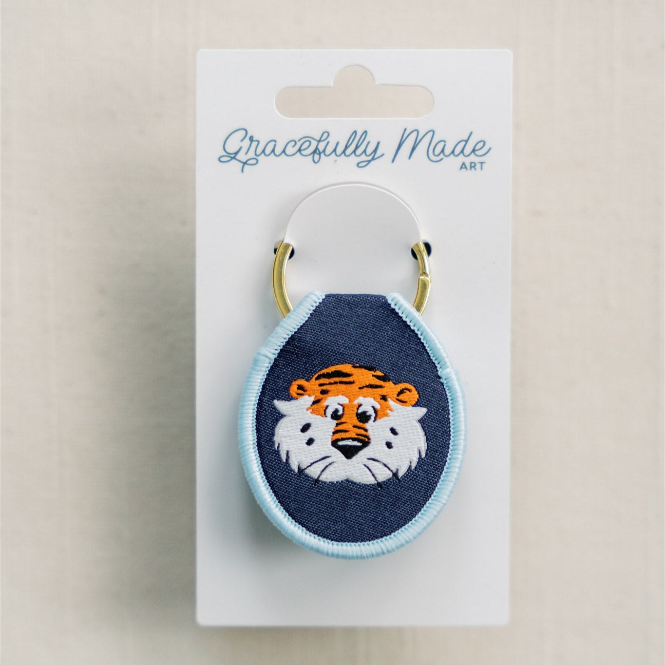 Navy blue keychain with light blue rim and Auburn embroidered on it.