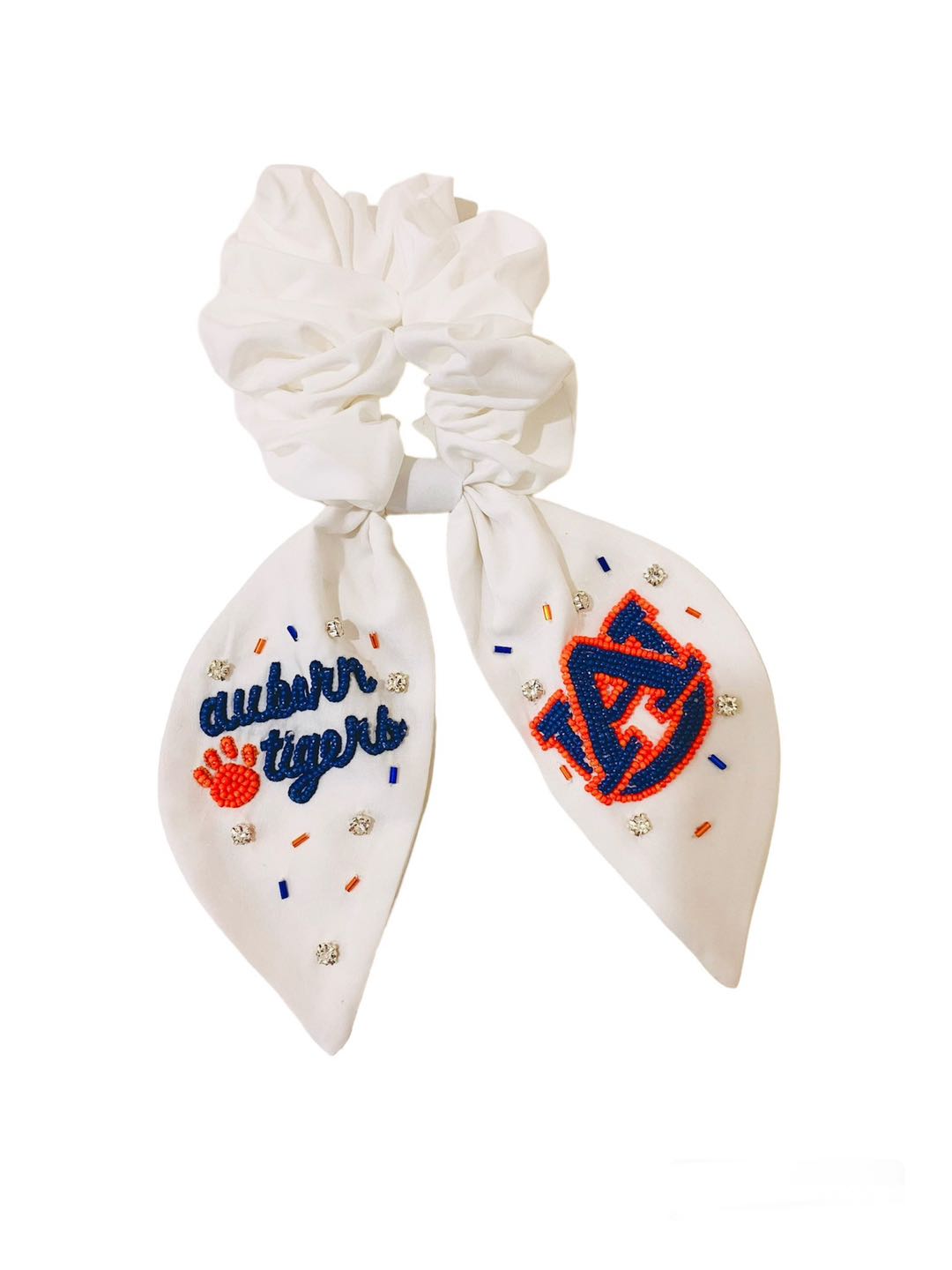 White scrunchie with two ribbons featuring beading of the Auburn logo and "Auburn Tigers."