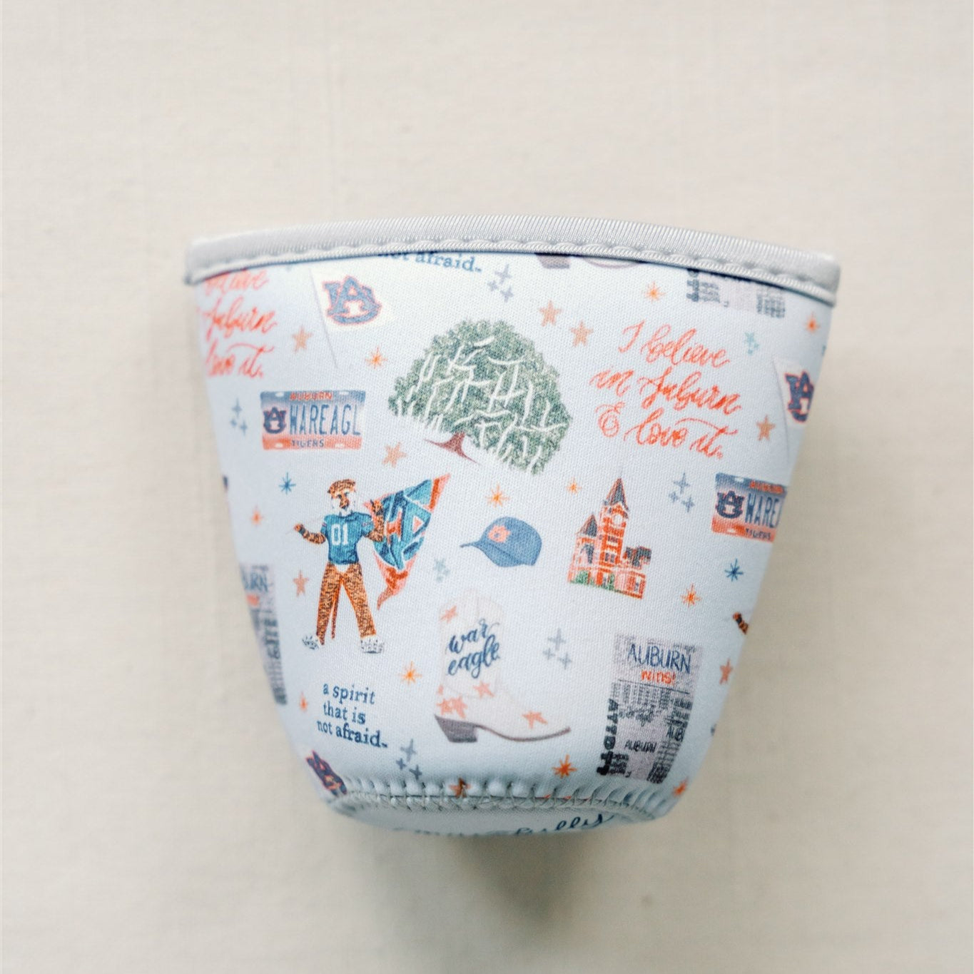 Light blue coffee sleeve with watercolor Auburn symbols.