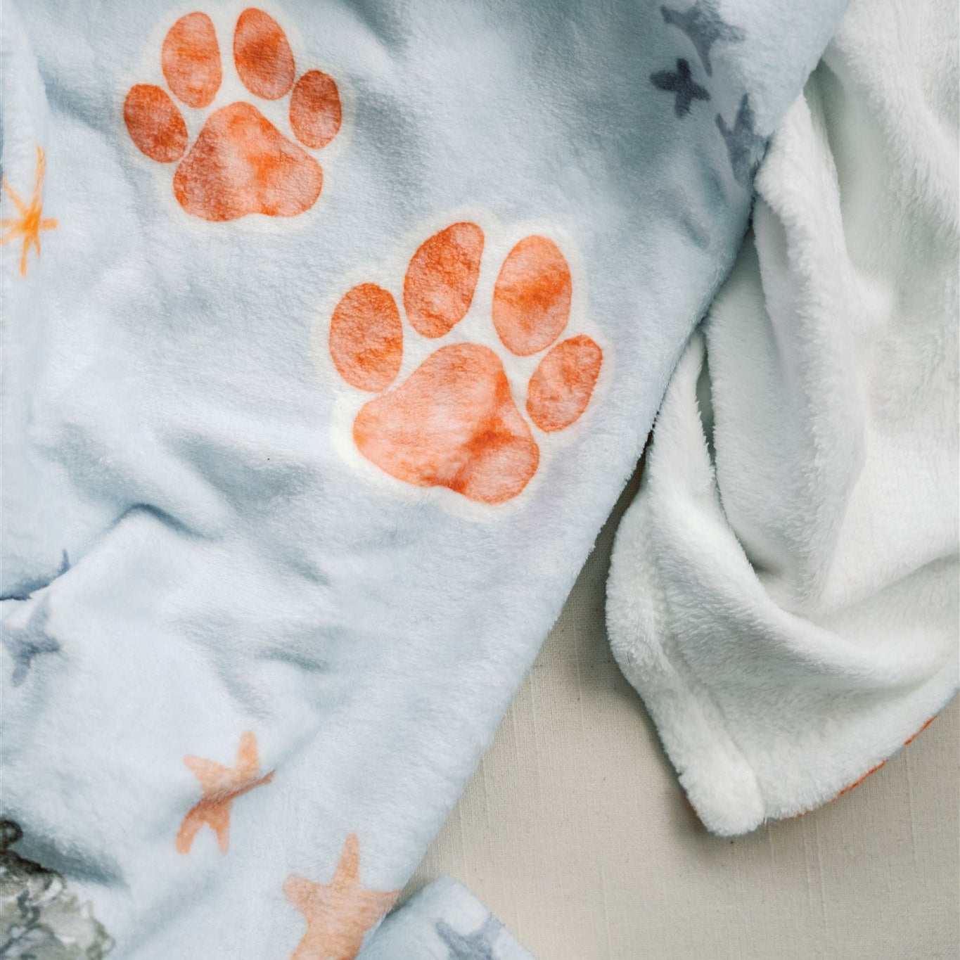 Light blue fleece blanket with watercolor Auburn University symbols.