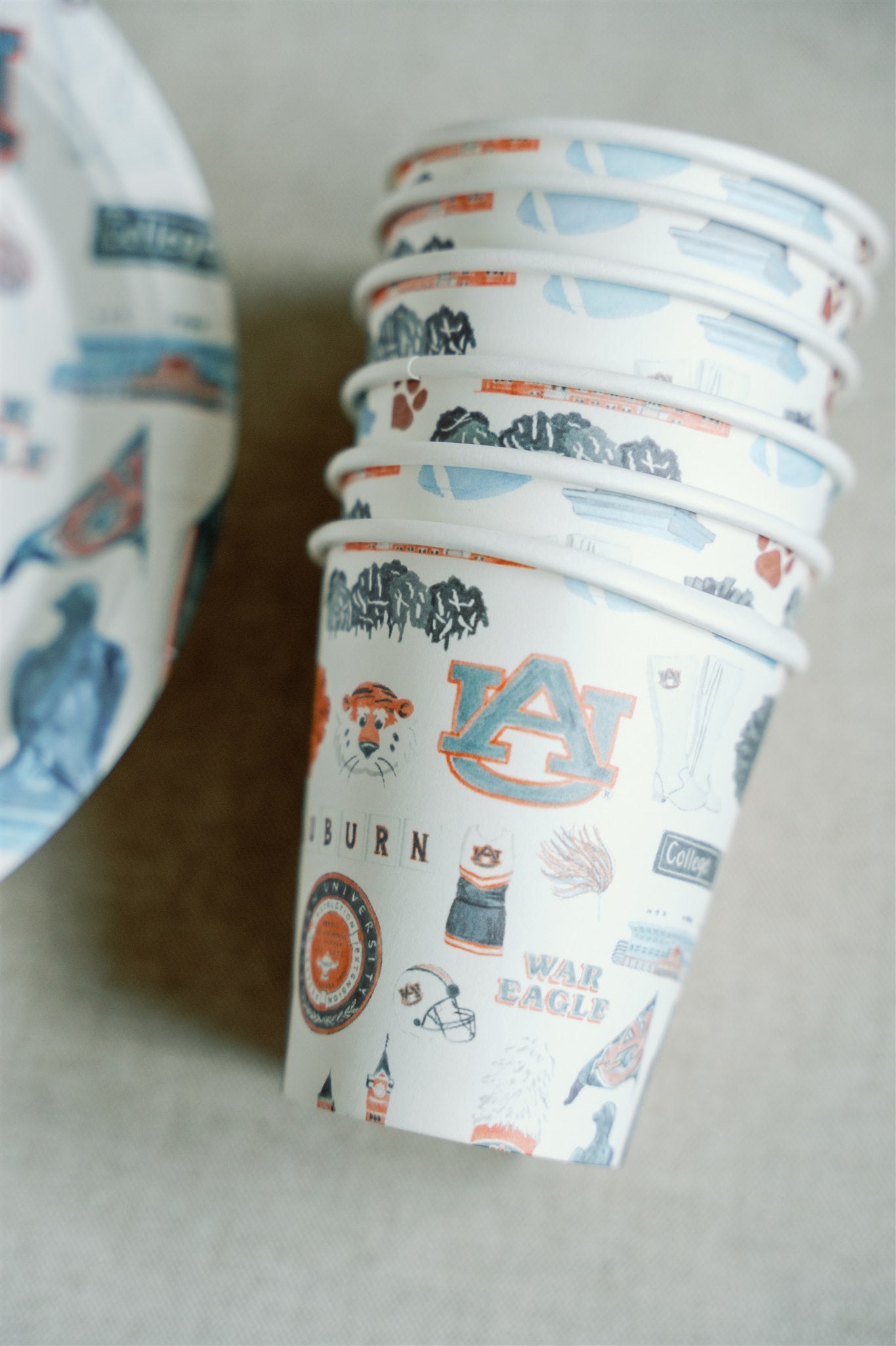 Paper cups with watercolor Auburn University icons and landmarks on them.