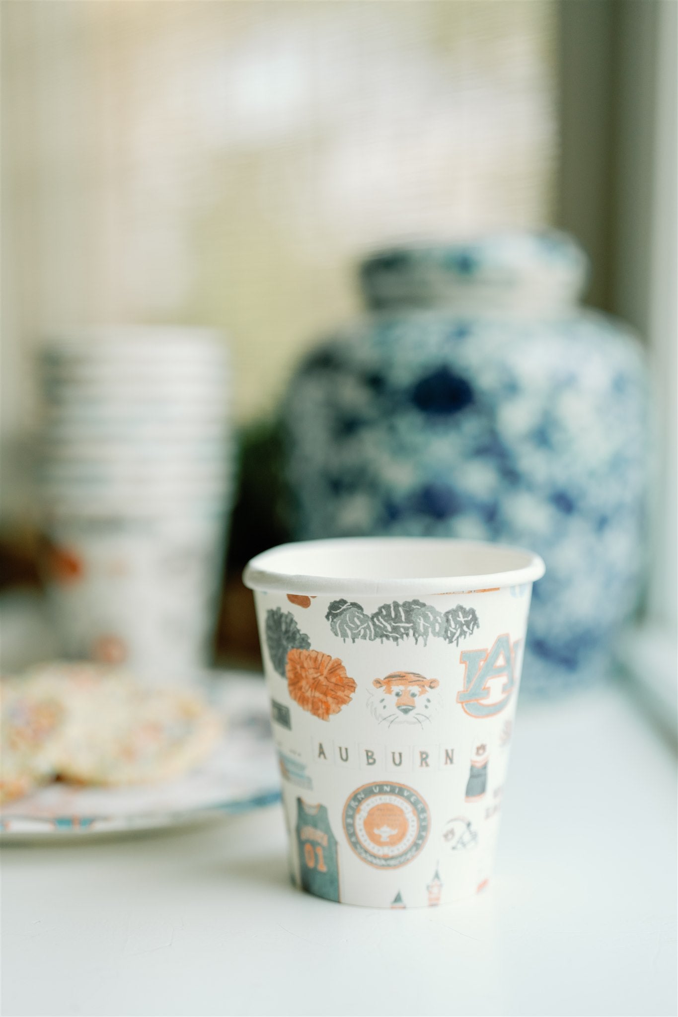 Paper cups with watercolor Auburn University icons and landmarks on them.