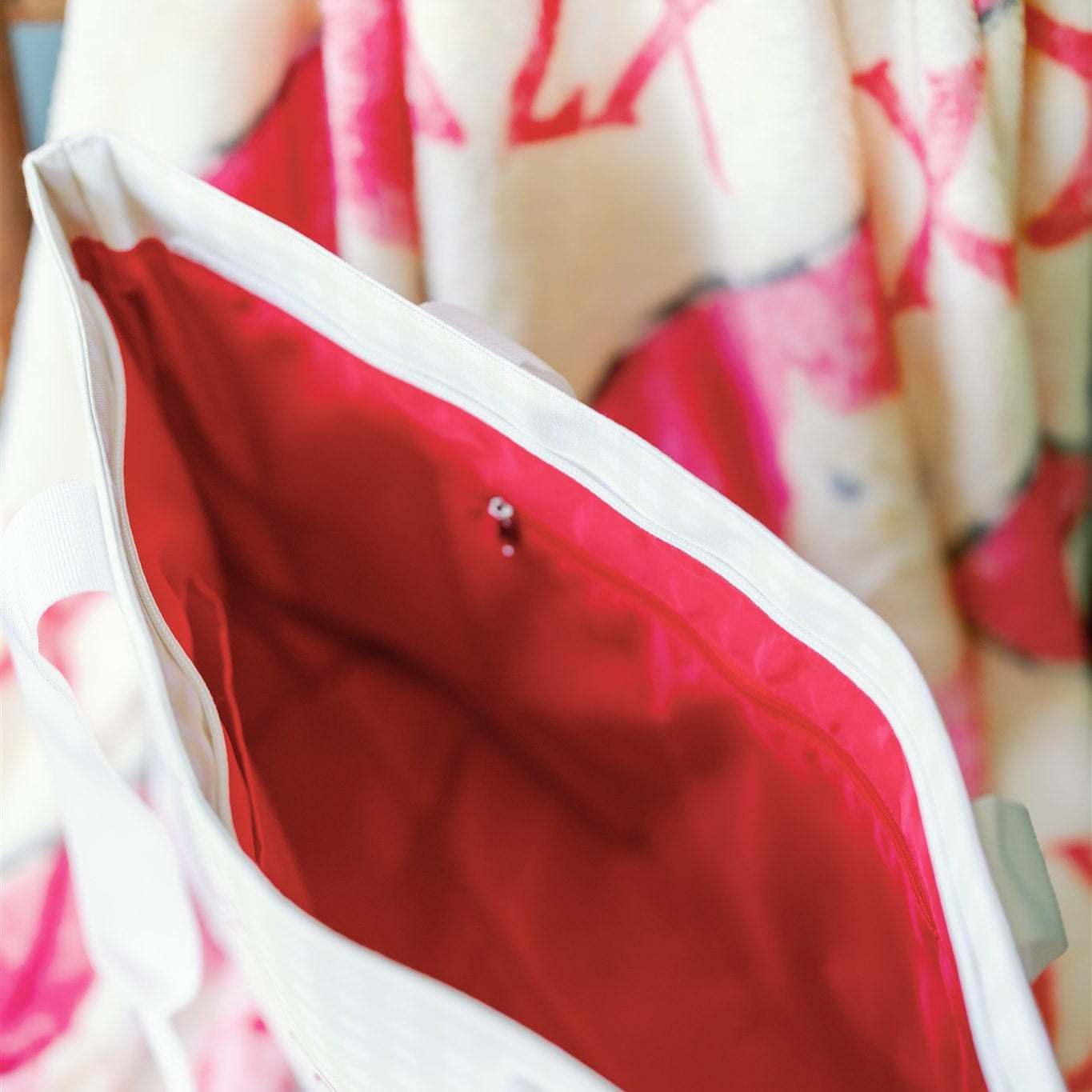 Close-up of a Chi Omega tote bag with red interior liner.