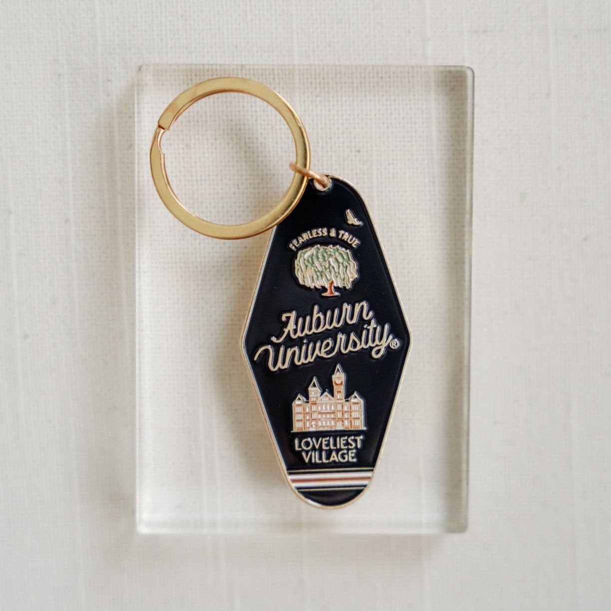 Navy blue enamel keychain on a gold chain with Auburn University written on it.