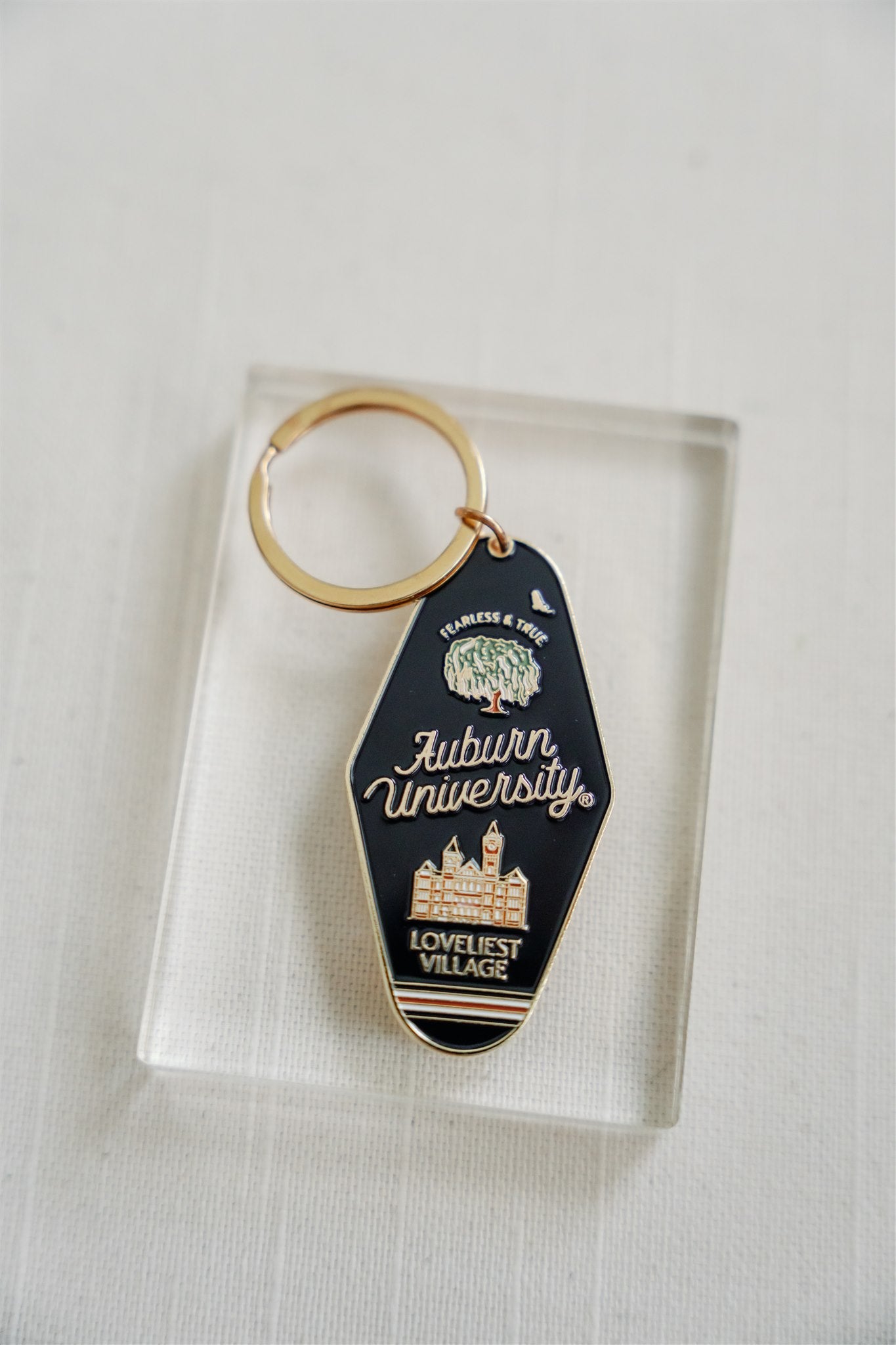 Navy blue enamel keychain on a gold chain with Auburn University written on it.