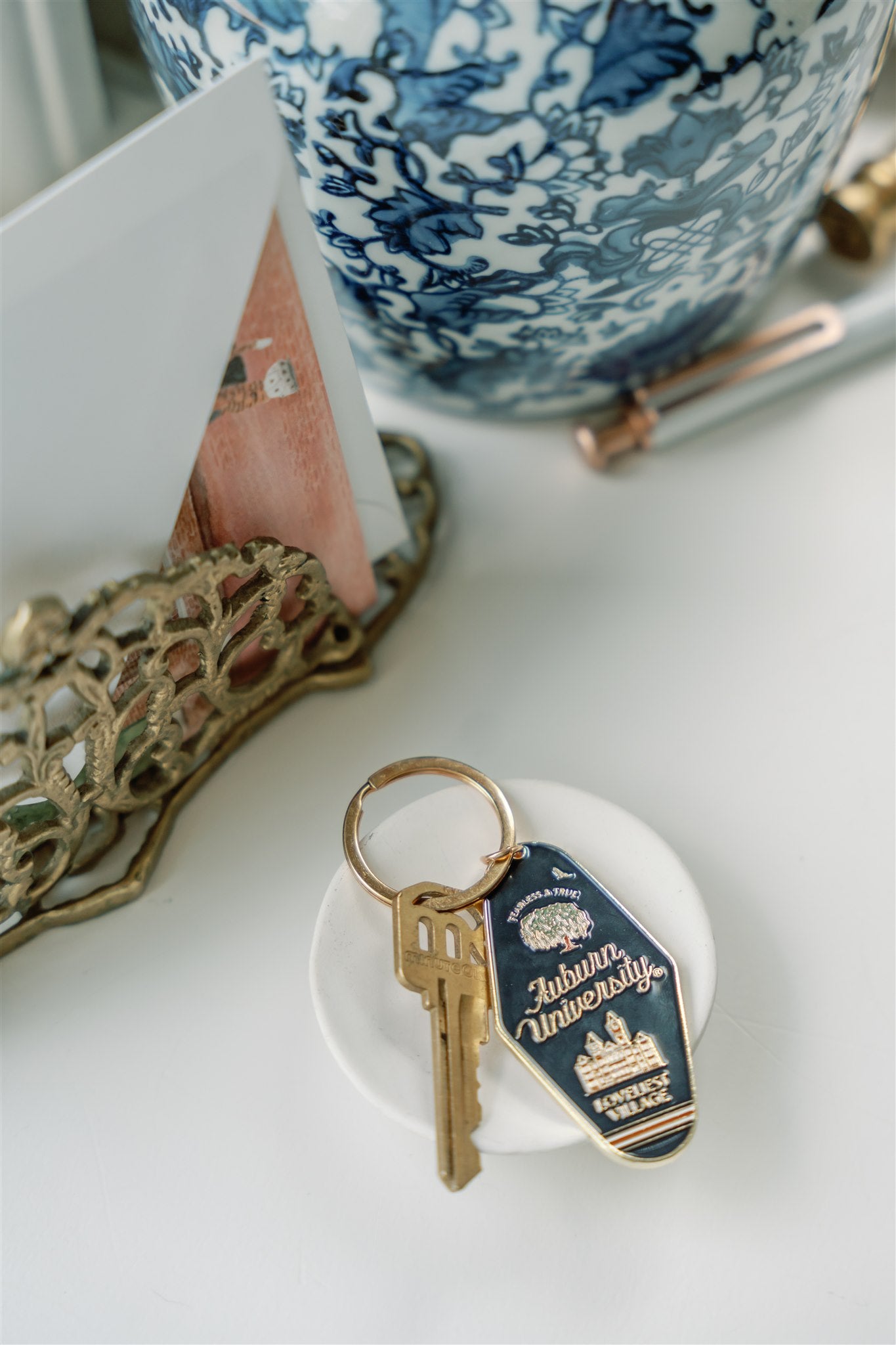Navy blue enamel keychain on a gold chain with Auburn University written on it.