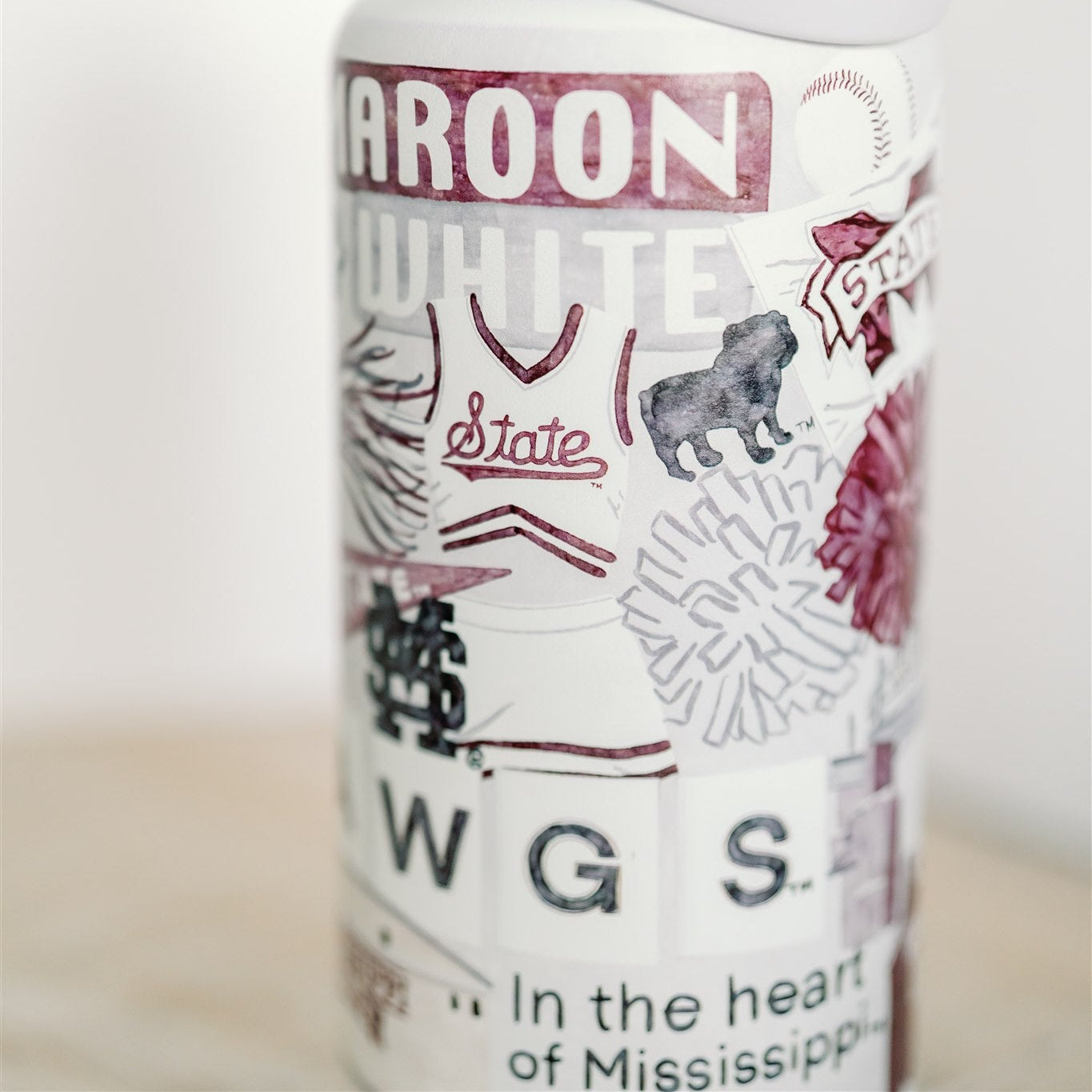 32 ounce water bottle with a white lid and is patterned with watercolor art of Mississippi State symbols.