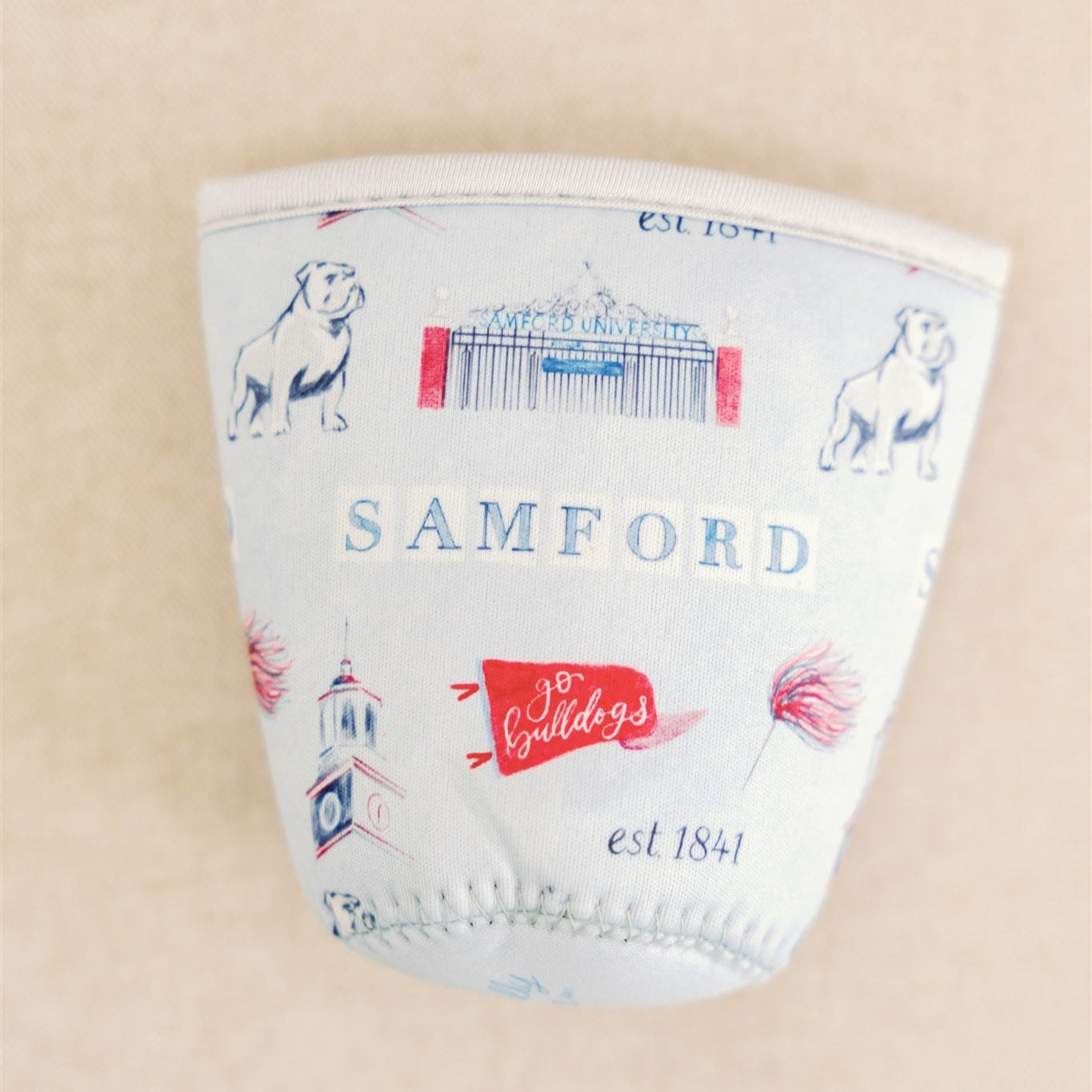 Light blue coffee sleeve with watercolor symbols themed to Samford University printed on it.