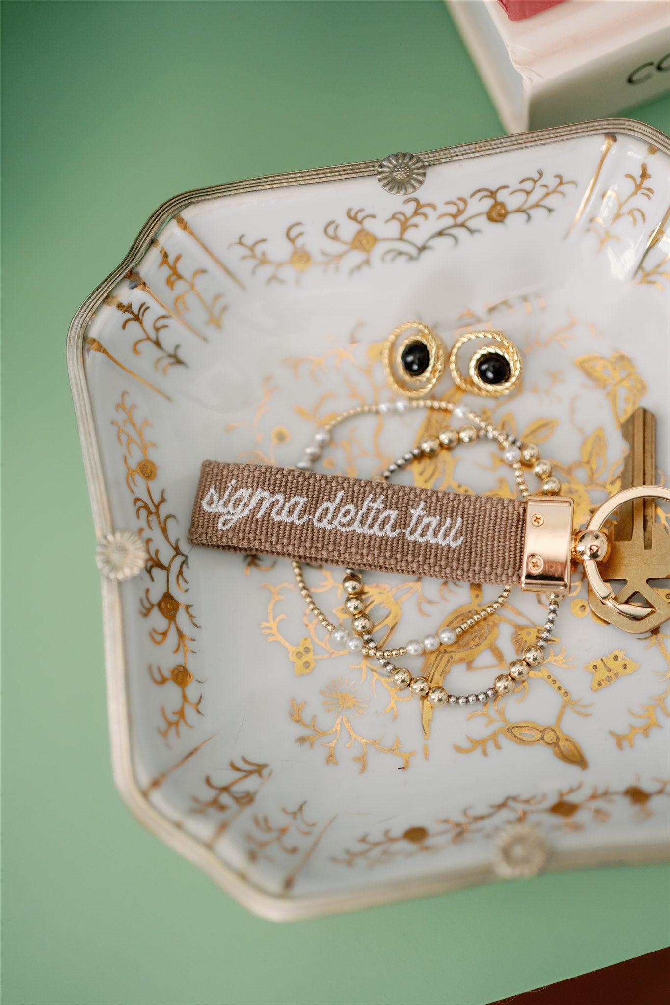 Sigma Delta Tau embroidered on a keychain set on a decorative jewelry dish.