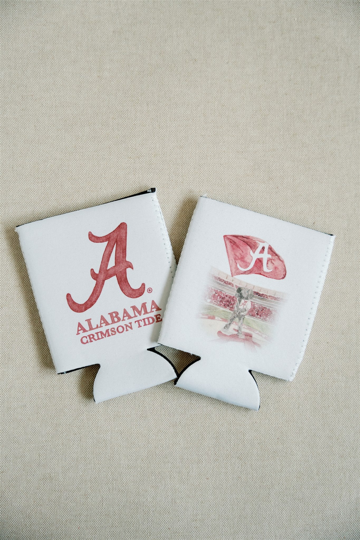 White Koozie with watercolor University of Alabama logo on one side and Big Al on the other side.