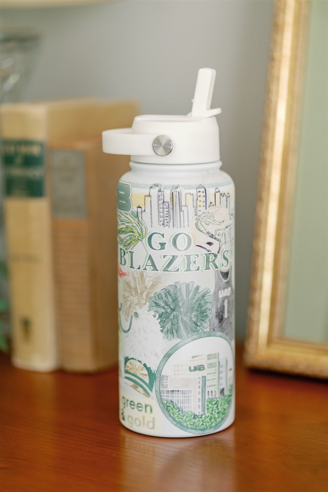 32 ounce water bottle with a white straw lid and collage of watercolor art of UAB symbols.