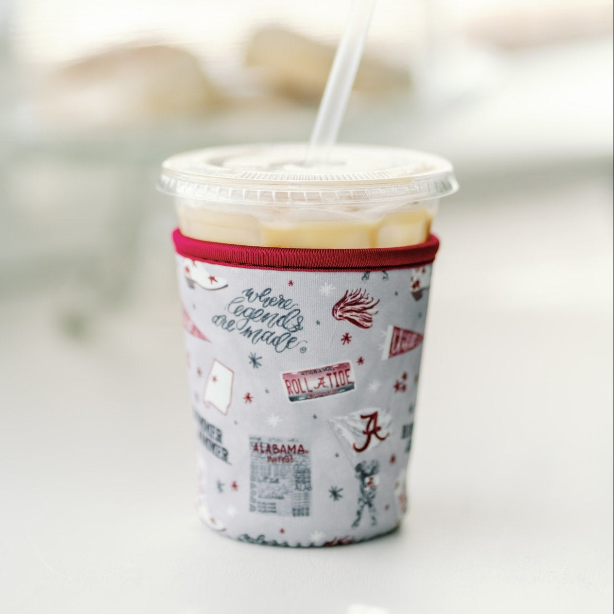 Light grey coffee sleeve with watercolor University of Alabama symbols.