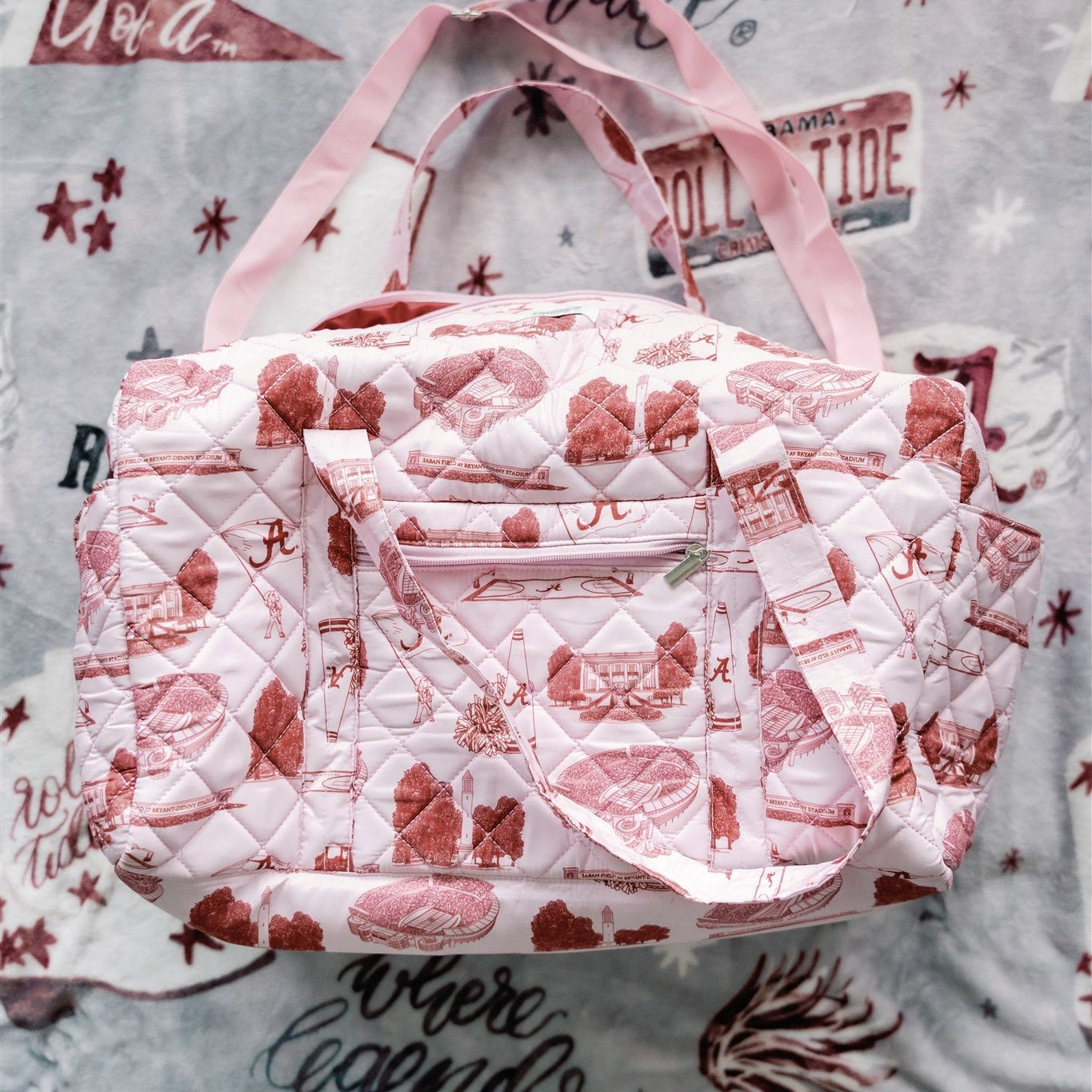 Light red quilted duffle bag with red University of Alabama symbols.
