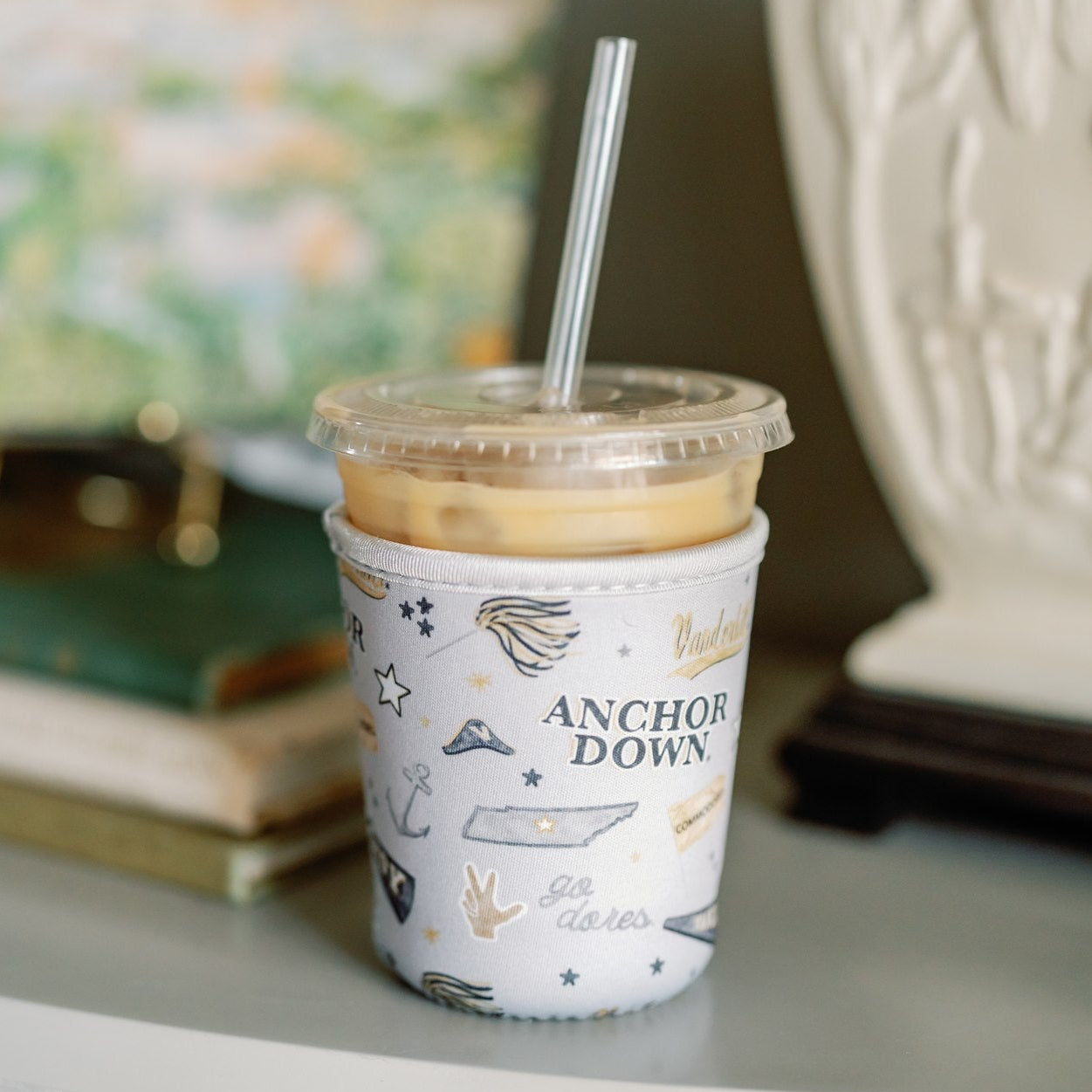 Light grey coffee sleeve with Vanderbilt University logos and symbols.