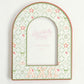 Close up of an arched picture frame with Alpha Chi Omega Greek letters and pattern.