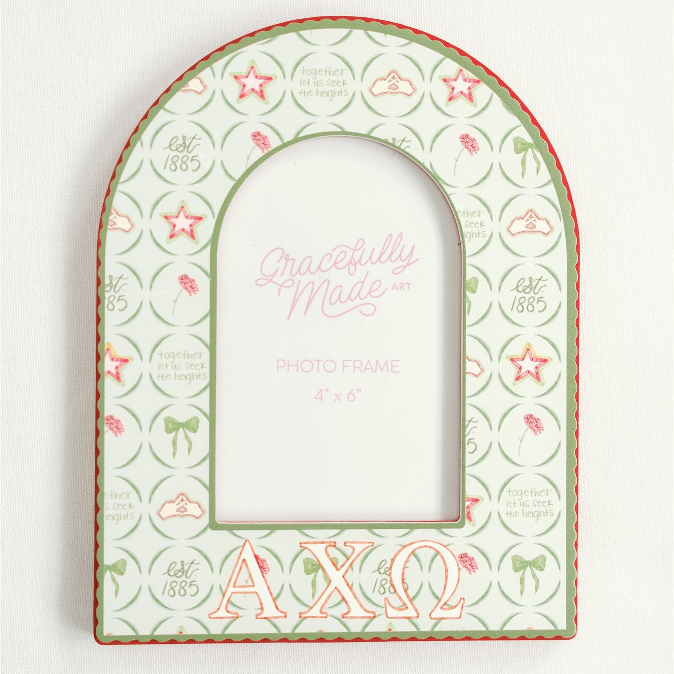 Close up of an arched picture frame with Alpha Chi Omega Greek letters and pattern.
