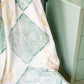 Blanket with 'Delta Alpha Chi Omega' letters on a green background