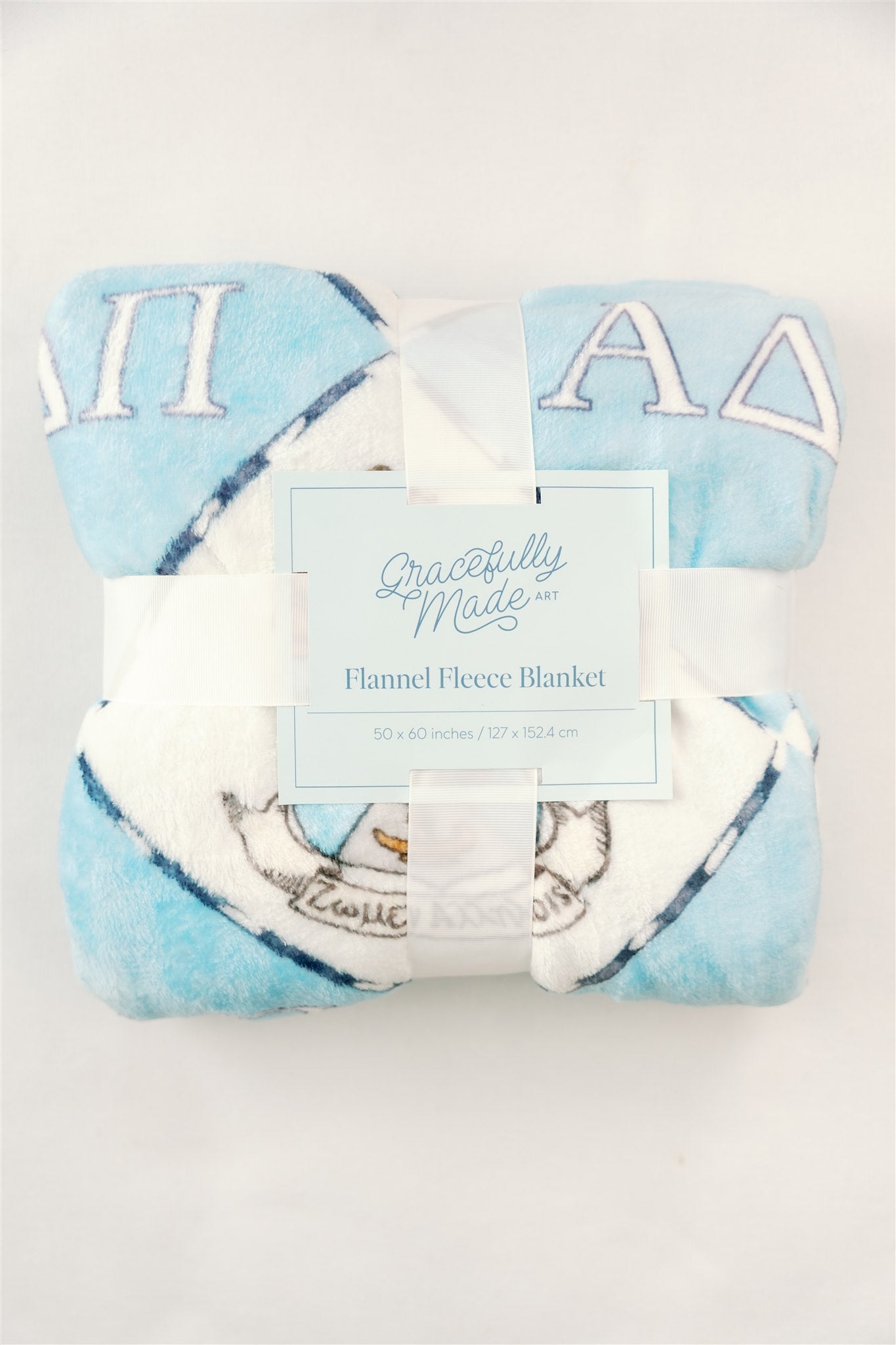 Folded flannel fleece blanket with a light blue background and Alpha Delta Pi Greek letters