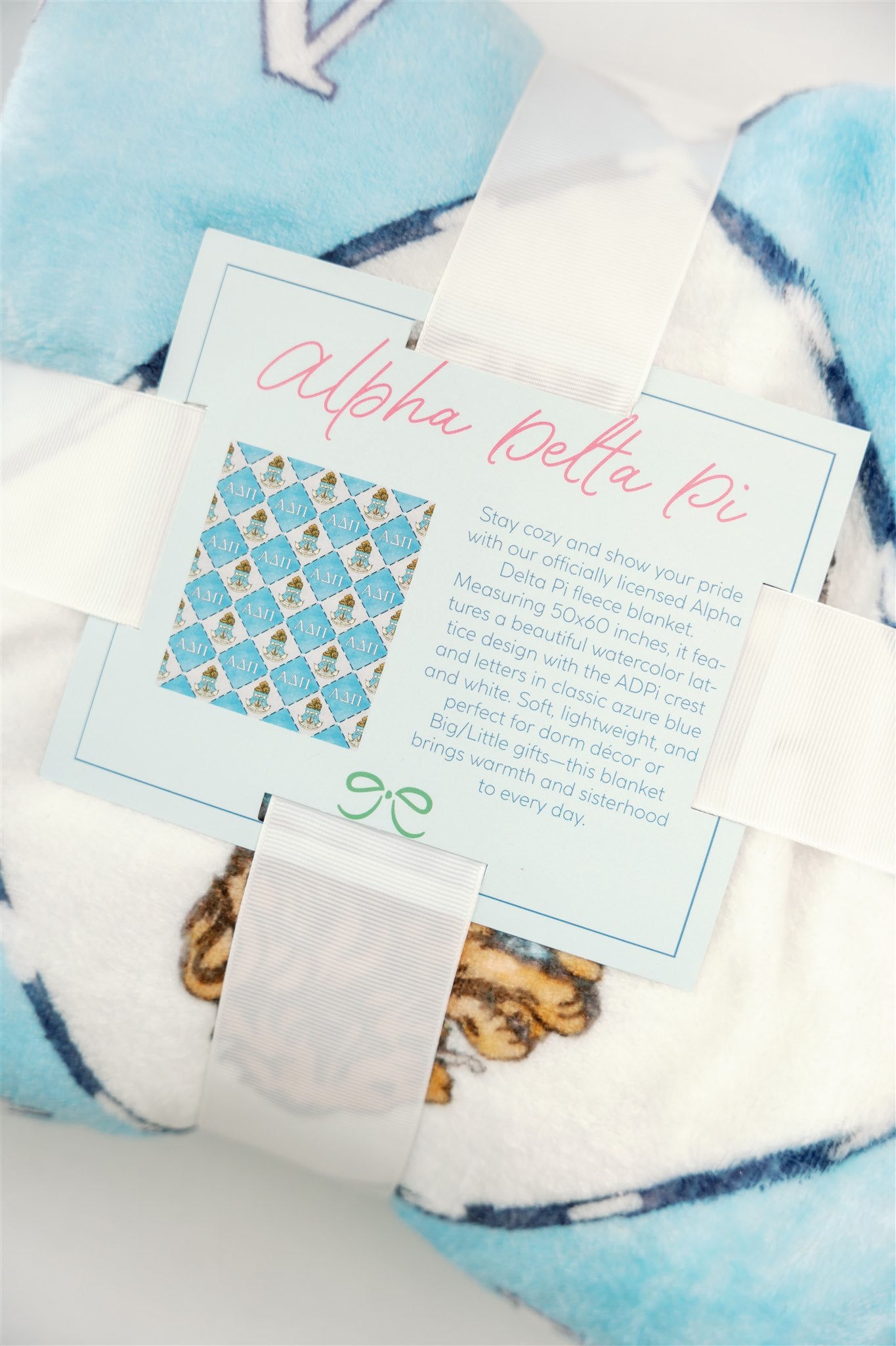 Blanket with 'Alpha Delta Pi' Greek letters and sorority symbols on a light blue background
