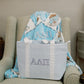 Blue gingham tote bag with Alpha Delta Pi Greek letters and white strap sitting on a chair.