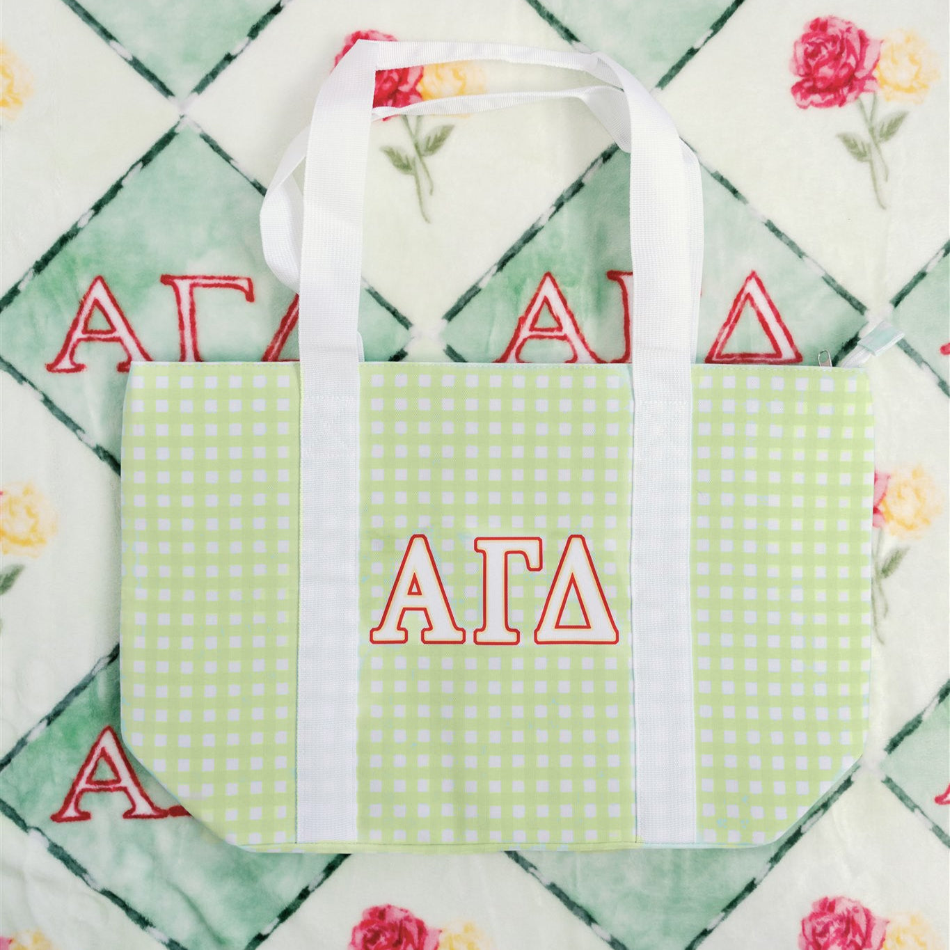 Tote bag with Alpha Gamma Delta Greek letters on a patterned background