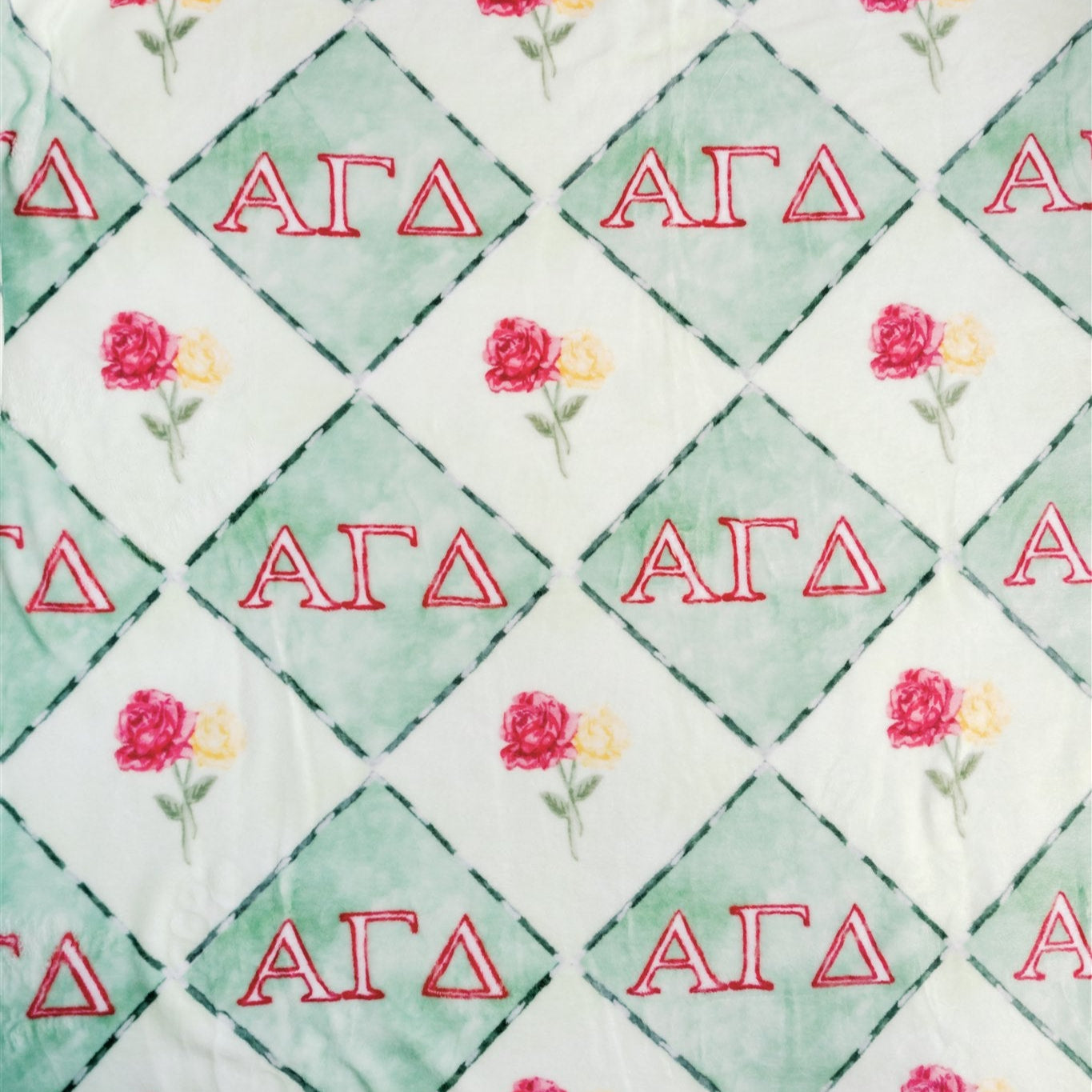 Fabric with red 'Alpha Gamma Delta' letters and floral patterns on a green and white checkered background.