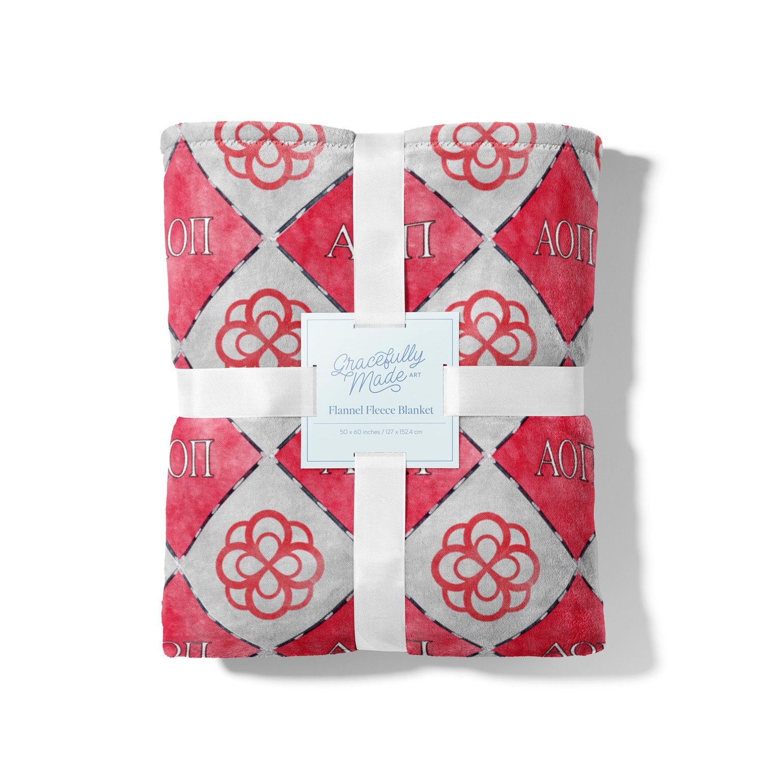 Folded red and gray fleece blanket with Alpha Omicron PI pattern