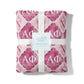 Pink patterned blanket with white ribbon and 'Gracefully Made' label on a white background