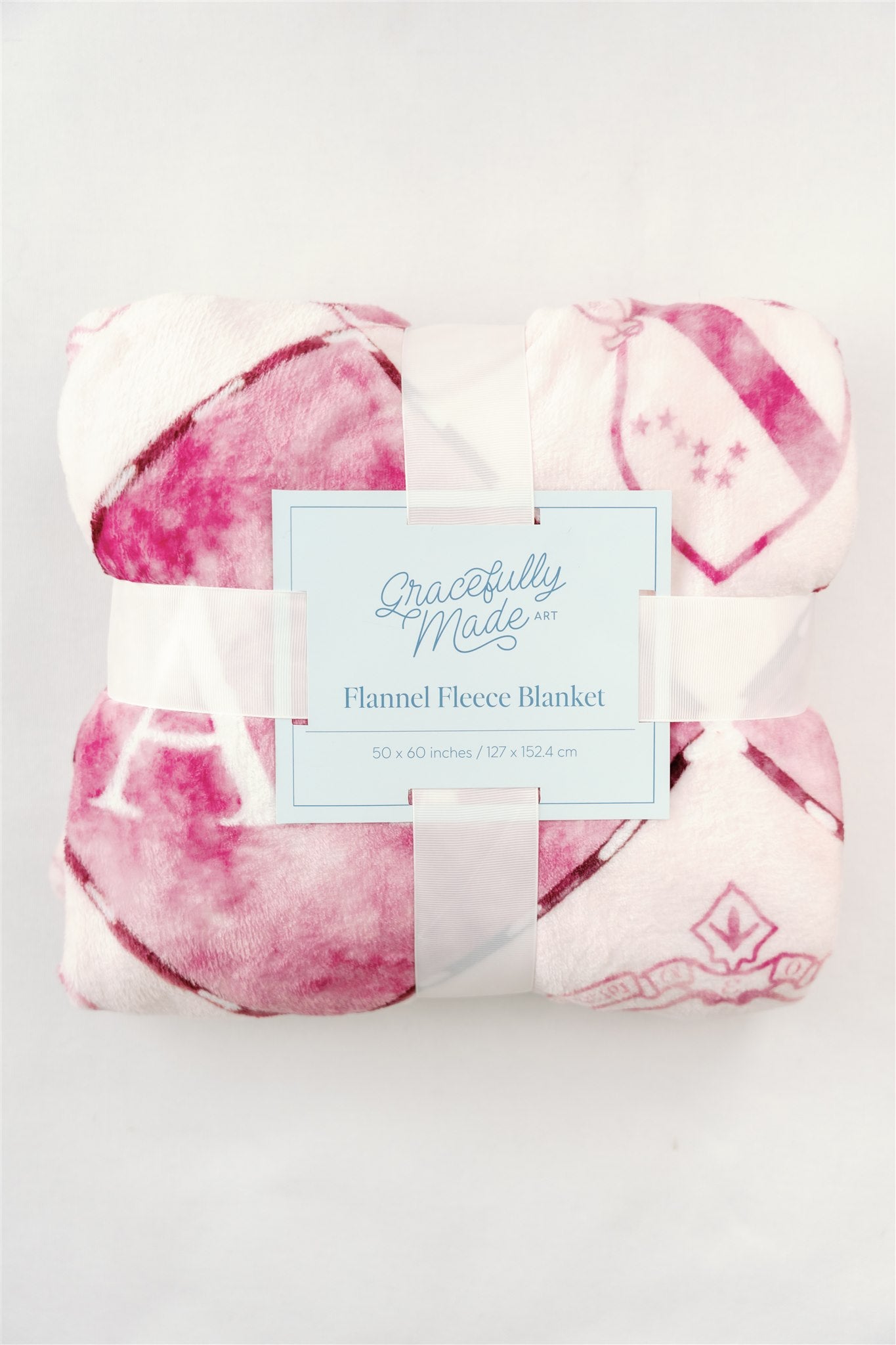Flannel fleece blanket with pink and white pattern and 'Gracefully Made' label on a light background