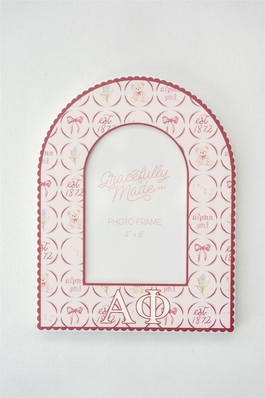 Decorative photo frame with Alpha Phi sorority designs and text on a white background