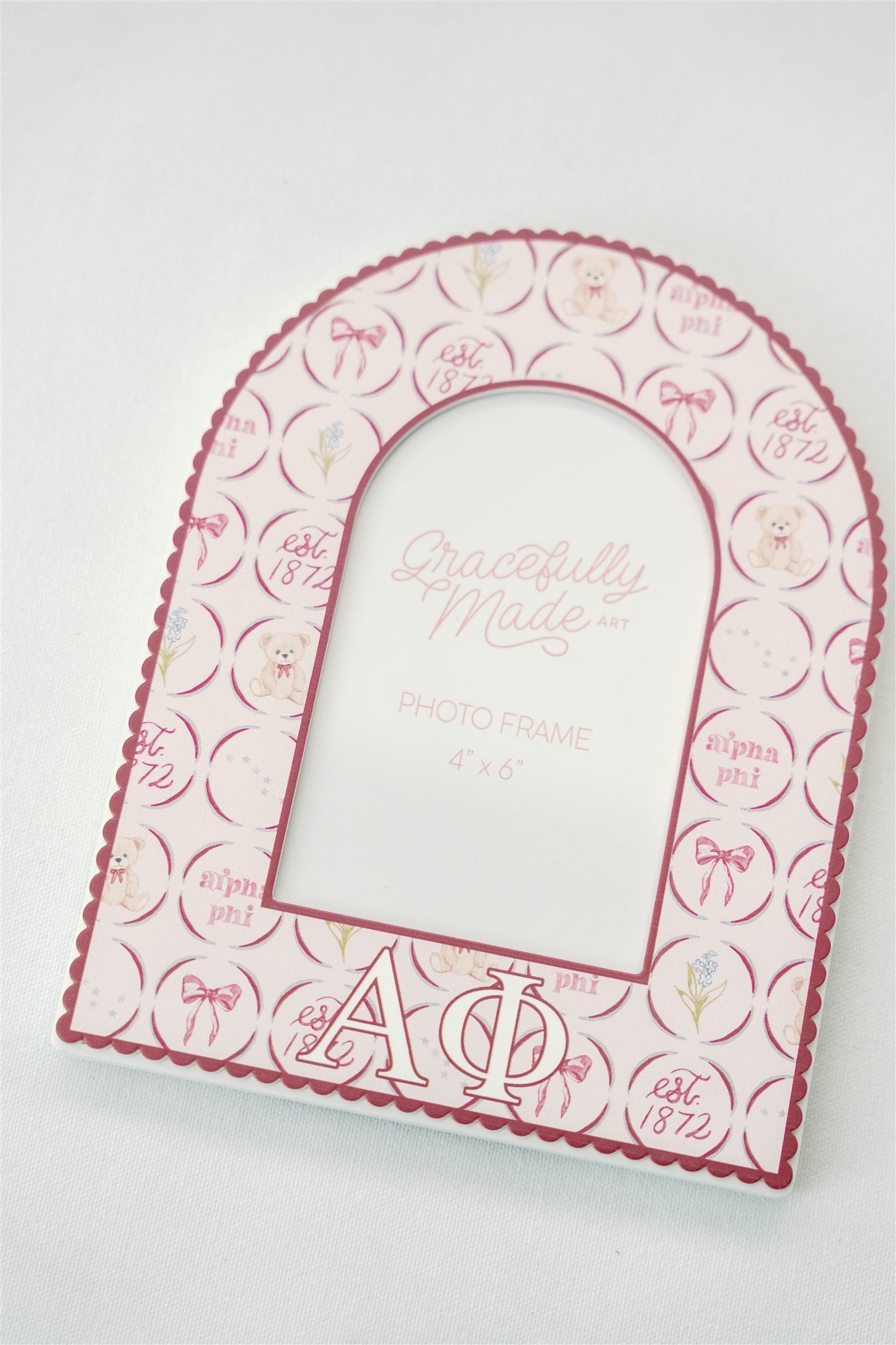 Arch-shaped photo frame with Alpha Phi decorative patterns and Greek letters on a white background.