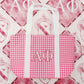 Pink gingham bag with 'ΑΦ' Greek letters on a fleece flannel blanket as the background.