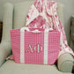 Pink gingham bag with Alpha Phi Greek letters on a green armchair