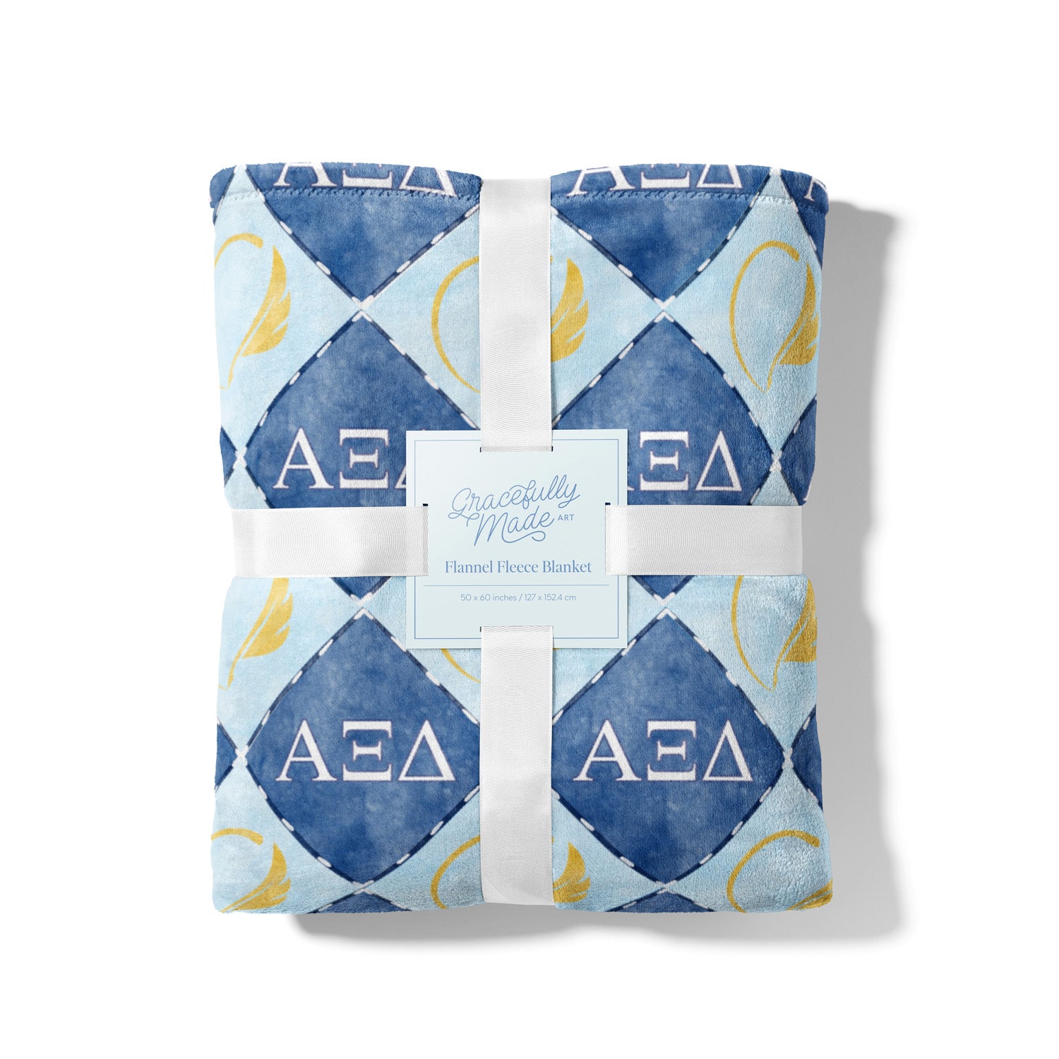 Folded blanket with dark and light blue diamond pattern and 'AEΣΔ' symbols