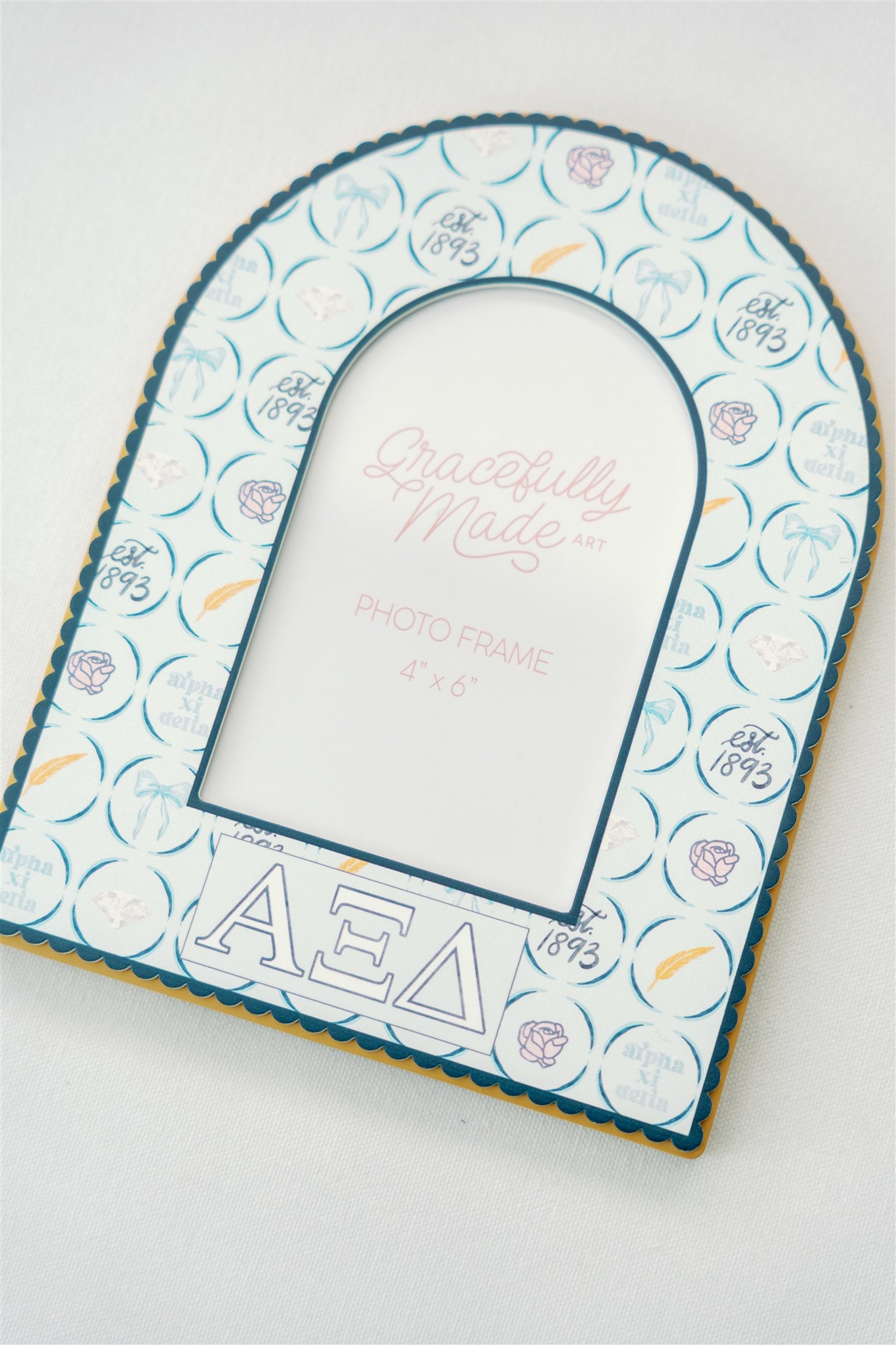 Decorative photo frame with Alpha Xi Delta patterns and Greek letters on a white background