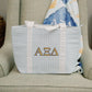 Light blue checkered tote bag with Alpha Xi Delta letters on a beige armchair