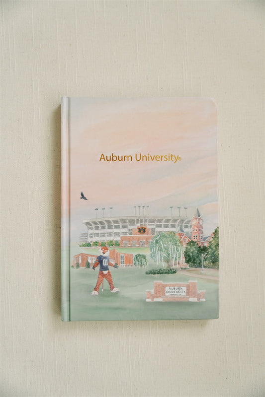 Hardcover notebook with watercolor illustration of Auburn and gold foil spelling "Auburn University."