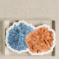 Sticker of an orange and blue pom pom.