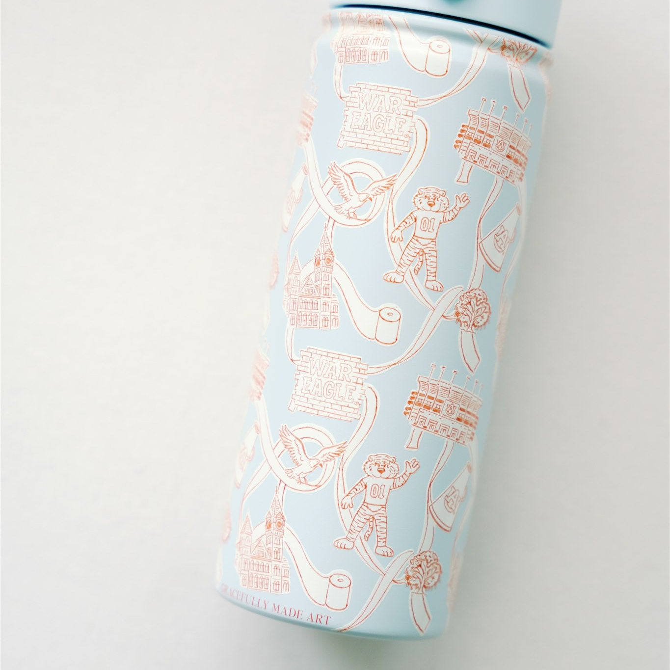 Light blue water bottle with orange and white Auburn University illustrations on a white background