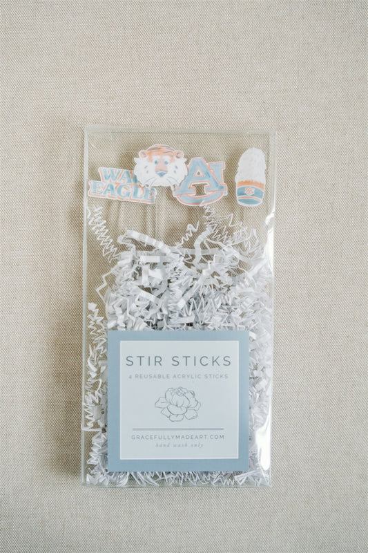 Acrylic stir sticks with watercolor Auburn University icons on the top of them.