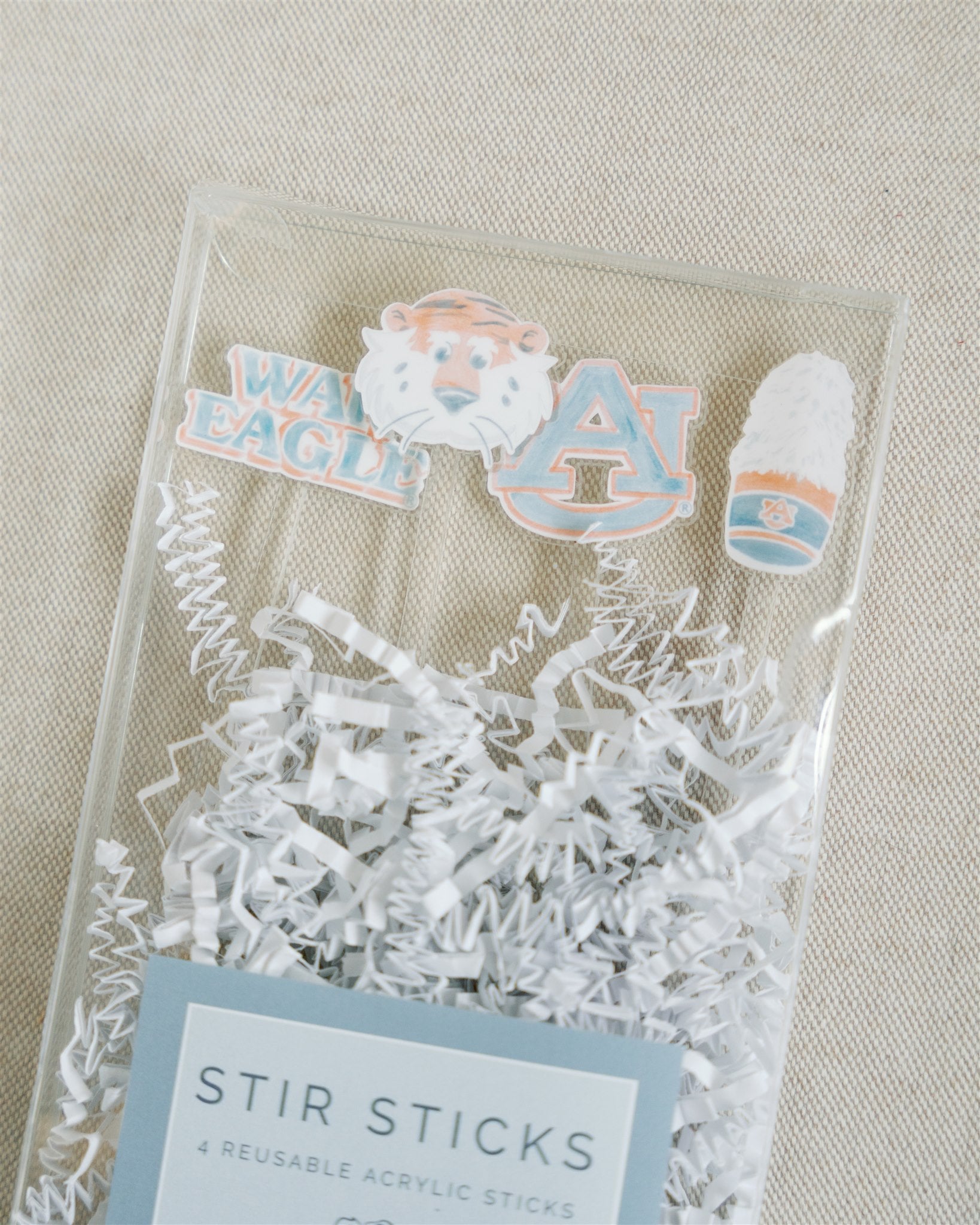 Acrylic stir sticks with watercolor Auburn University icons on the top of them.