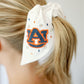 White scrunchie with two ribbons featuring beading of the Auburn logo and "Auburn Tigers."