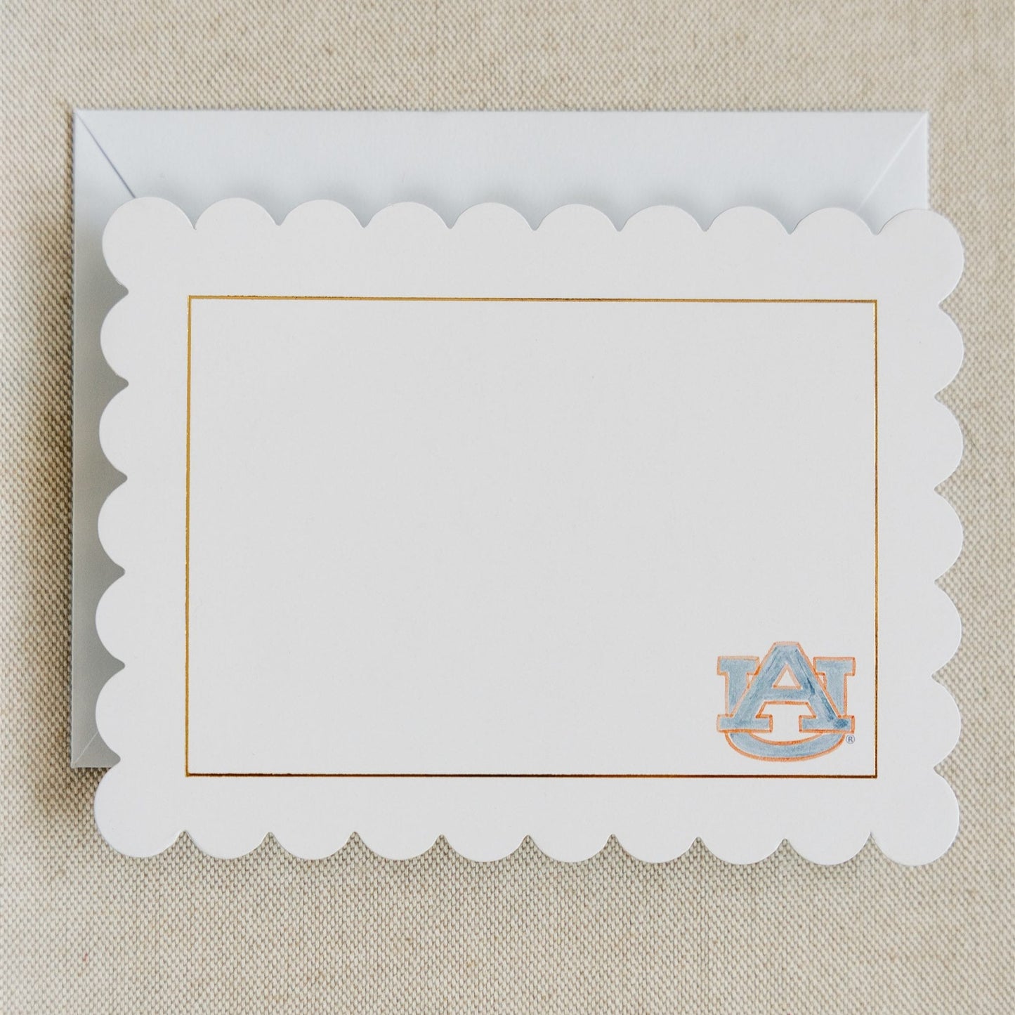 Stationery with scalloped edges, a gold rim, and a watercolor Auburn logo.