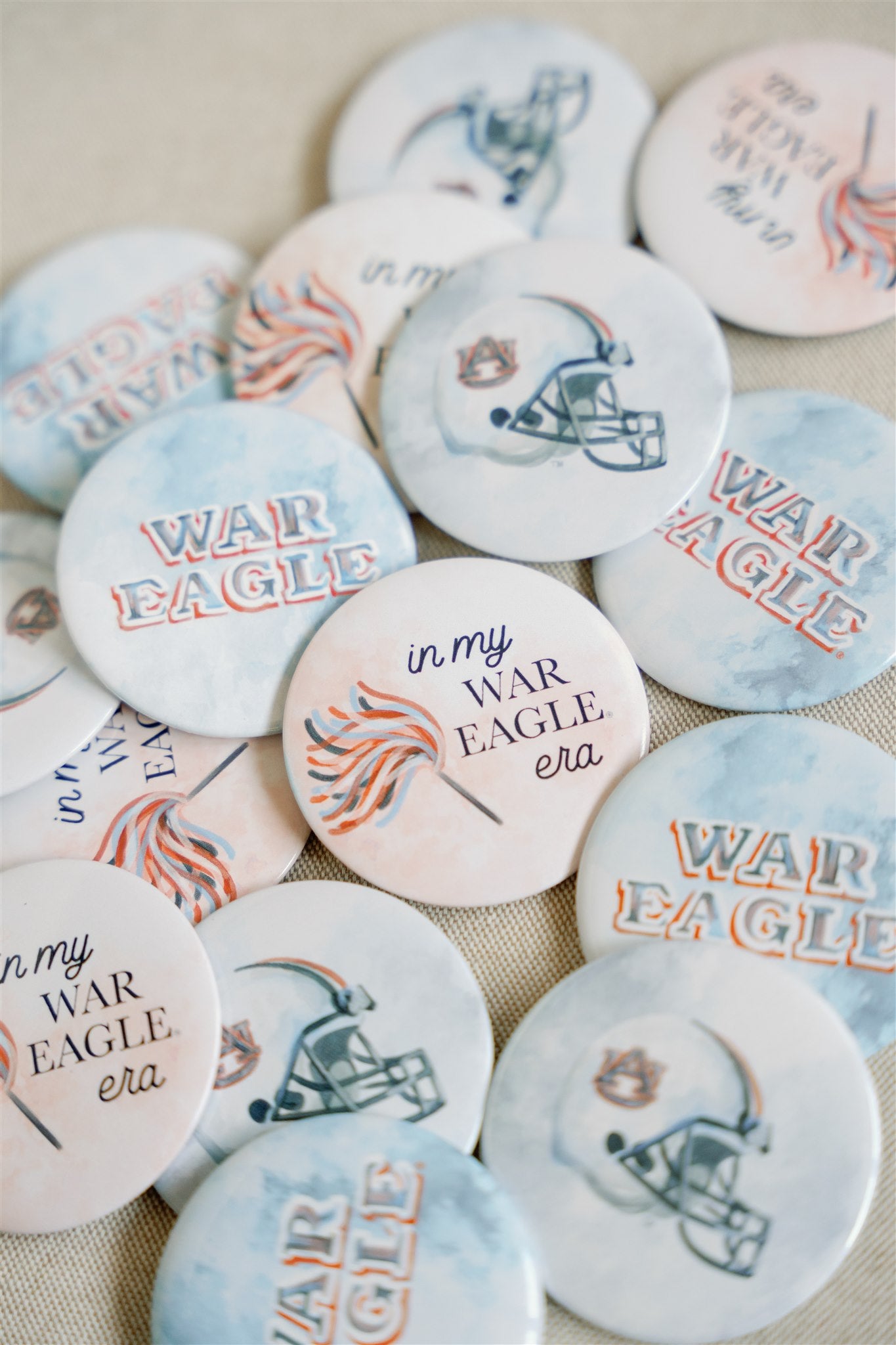 Button with "in my War Eagle era" and a pom pom on it.