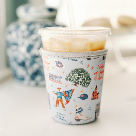 Light blue coffee sleeve with watercolor Auburn symbols. 
