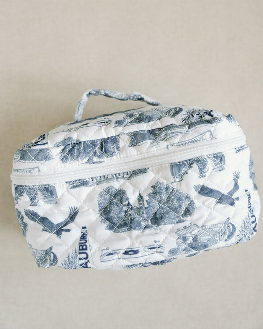 White quilted makeup bag with navy blue Auburn University symbols.