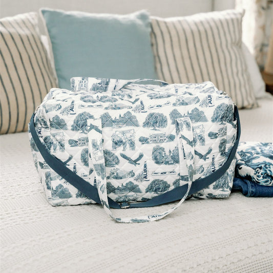 White quilted duffle bag with a navy strap and navy Auburn symbols.